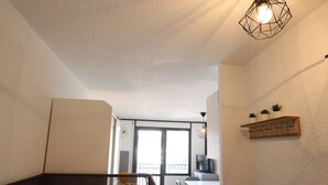 Une chambre d’hôtel avec un lit, un bureau et une chaise, une télévision et une fenêtre.
