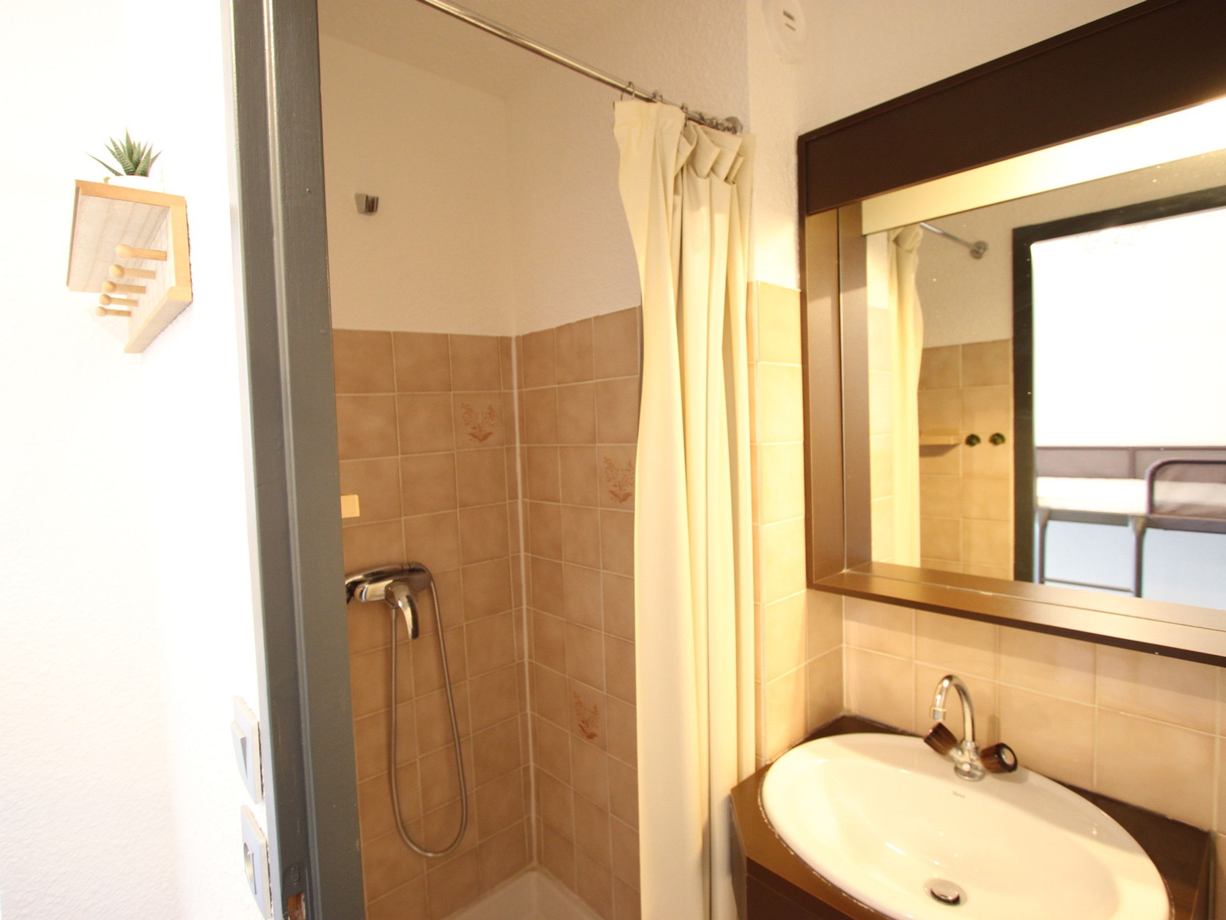Un baño con ducha, lavabo y espejo.