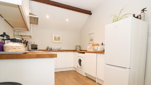 Eine kleine Küche mit Mikrowelle, Toaster und Kühlschrank.