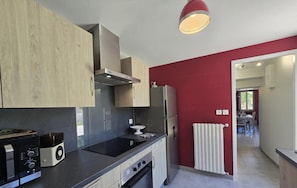 Una cocina moderna con encimera negra, electrodomésticos de acero inoxidable y armarios de madera.