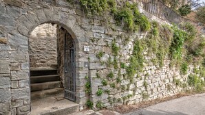 Ein Steinhaus mit einem Metallgitter, Stufen, die zu einem Eingang führen, und einem Schild, das einen Preis von 5 anzeigt.
