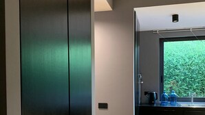 A modern kitchen with dark cabinetry, a large window, and a wooden floor. - LeMummarelle36Apartment (Naples)