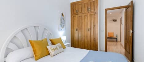 A bedroom with a bed, a wardrobe, and a bathroom visible through an open door.