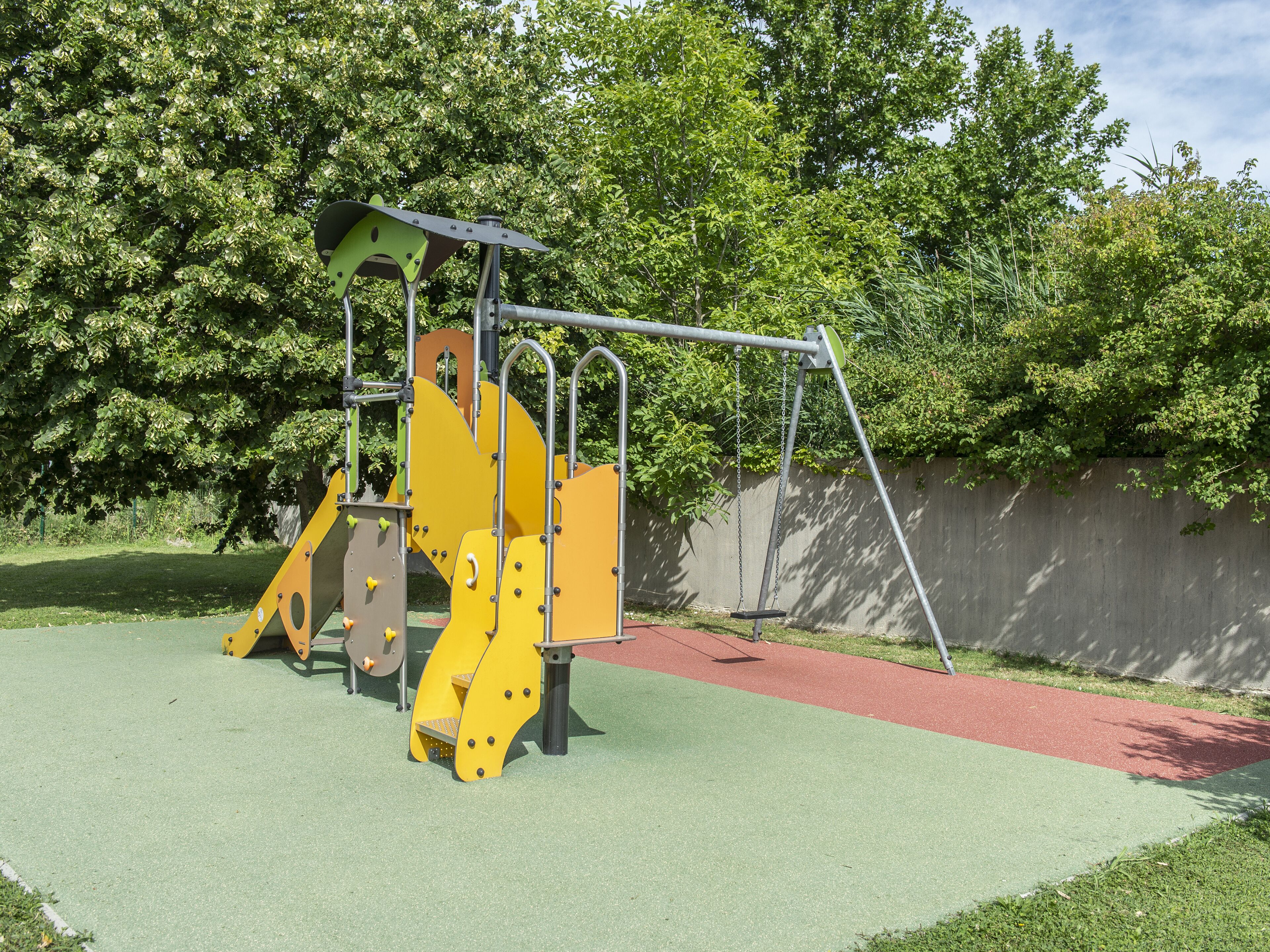 A playground with a swing set and climbing structures.