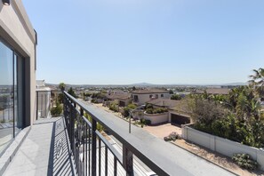 A residential area with houses, a clear sky, and a balcony with a railing. - Villa Balmoral 14 (Cape Town)