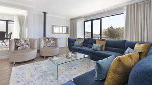 A modern living room with a sectional sofa, a glass coffee table, and a patterned rug. - Villa Balmoral 14 (Cape Town)