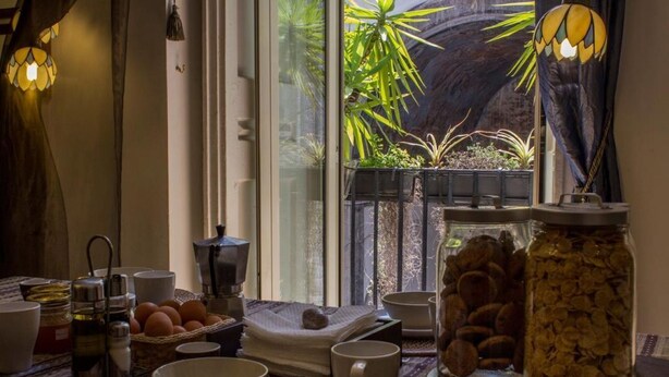 Une table de petit-déjeuner installée devant une fenêtre offrant une vue sur un paysage rocheux.