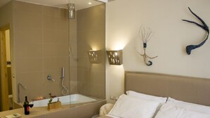 Una habitación de hotel con cama, baño con bañera y ducha.