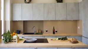 Una cocina moderna con encimera de madera, un lavamanos integrado y una salpicadera.