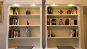 Two white bookshelves with books, decorative items, and a vase. - Sui Tetti di Napoli - in the heart of authentic naples (Napoli)