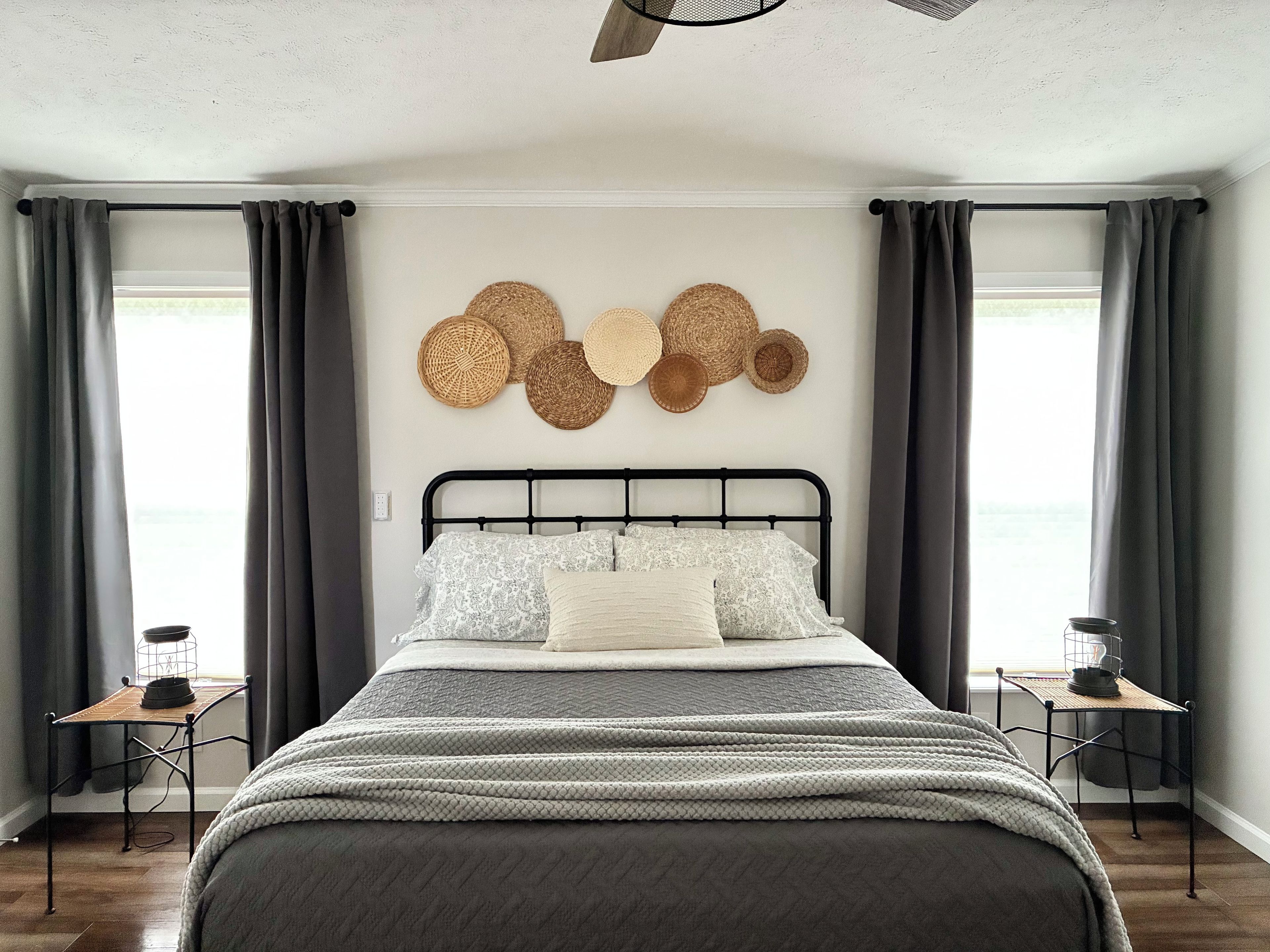 Une chambre moderne avec un lit, des tables de chevet et un mur décoré de paniers tressés.