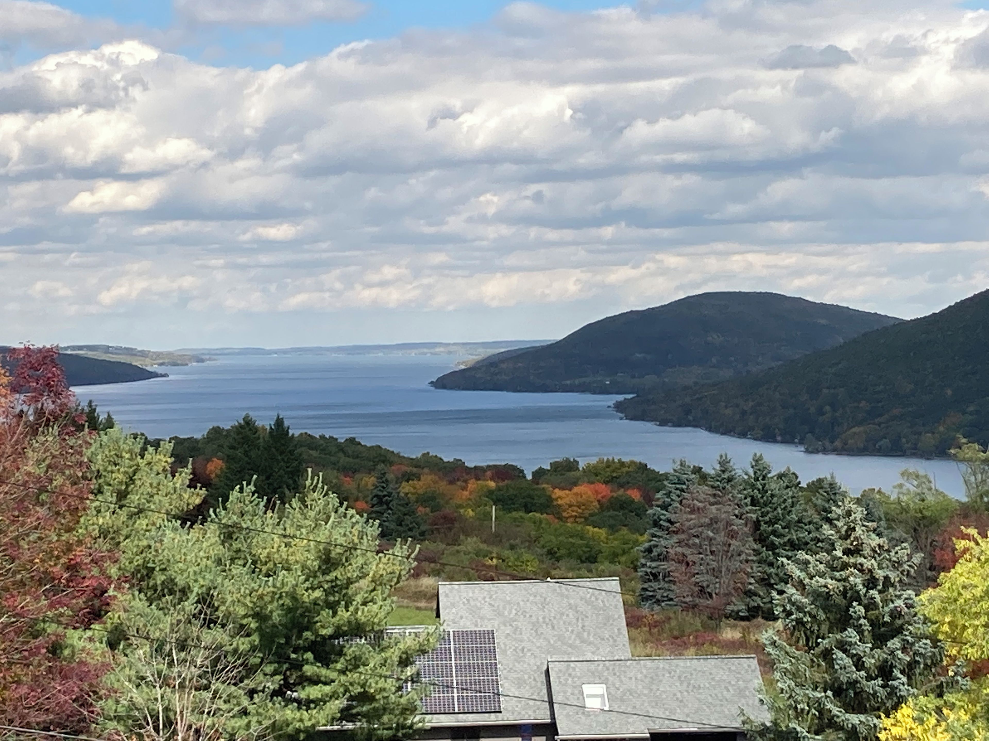 A view of a lake surrounded by hills and trees.