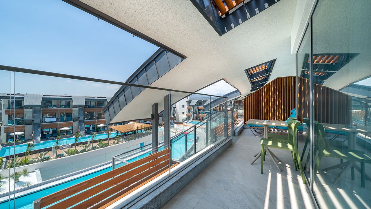 Ett modernt hotell med poolområde, utomhusplats och utsikt över andra byggnader.