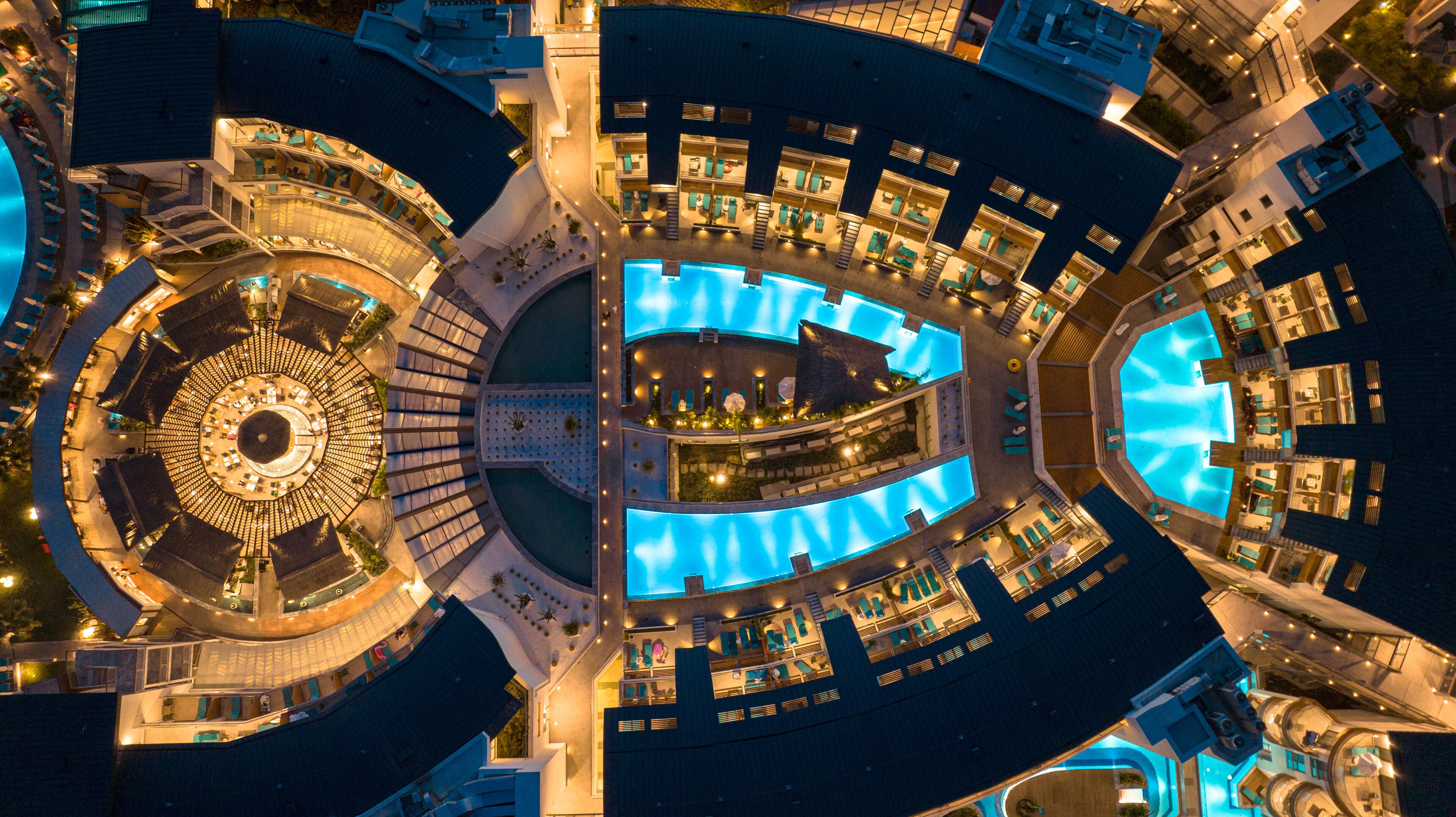 Un hôtel moderne doté de plusieurs piscines, d’une cour intérieure et d’une conception circulaire.