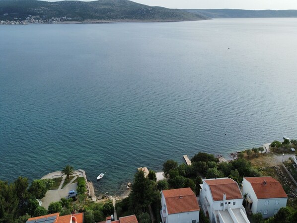 A coastal view with buildings, a boat, and a calm sea.