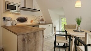Uma cozinha moderna com ilha de madeira, armários brancos e um espaço de refeições com mesa e cadeiras.
