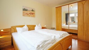 Ein Schlafzimmer mit einem großen Bett, einem Holzschrank und einem Gemälde an der Wand.