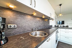 Een koelkast, een oven, een kookplaat, een vaatwasser