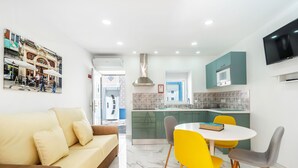 Een modern appartement met woonkamer, eethoek en keuken.