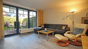 Een moderne woonkamer met een bank, een schommelstoel en een salontafel.