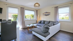 Een moderne woonkamer met een bank, een eettafel en een televisie.