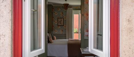 Un dormitorio con cama, ventana y vista al exterior.