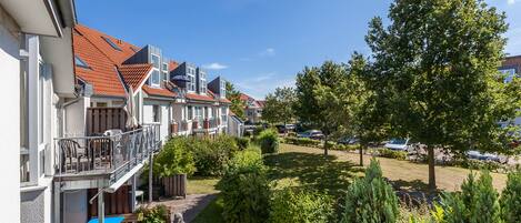 A residential area with houses, a swimming pool, and well-maintained gardens.