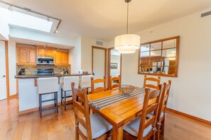 Eine moderne Küche mit Holzausbau, einer zentralen Kochinsel und einem Essbereich mit Holztisch und Stühlen.