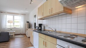 Una cocina moderna con armarios de madera, estufa integrada y un lavabo.