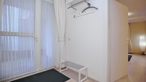 A room with a large window, a drying rack, and a door leading to another room. - Die Ferienwohnung Nr (Ostseebad Boltenhagen)