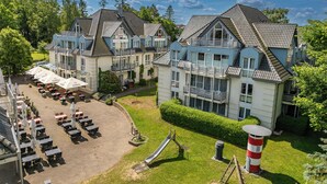 Un grande hotel con diversi edifici, aree salotto all'aperto e un parco giochi.