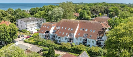 Ein Wohngebiet mit einer Häuserreihe, rote Ziegeldächer und Blick auf das Meer.