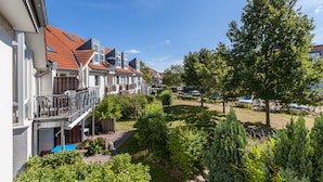 Række af byhuse med altaner, swimmingpool og velplejede haver.