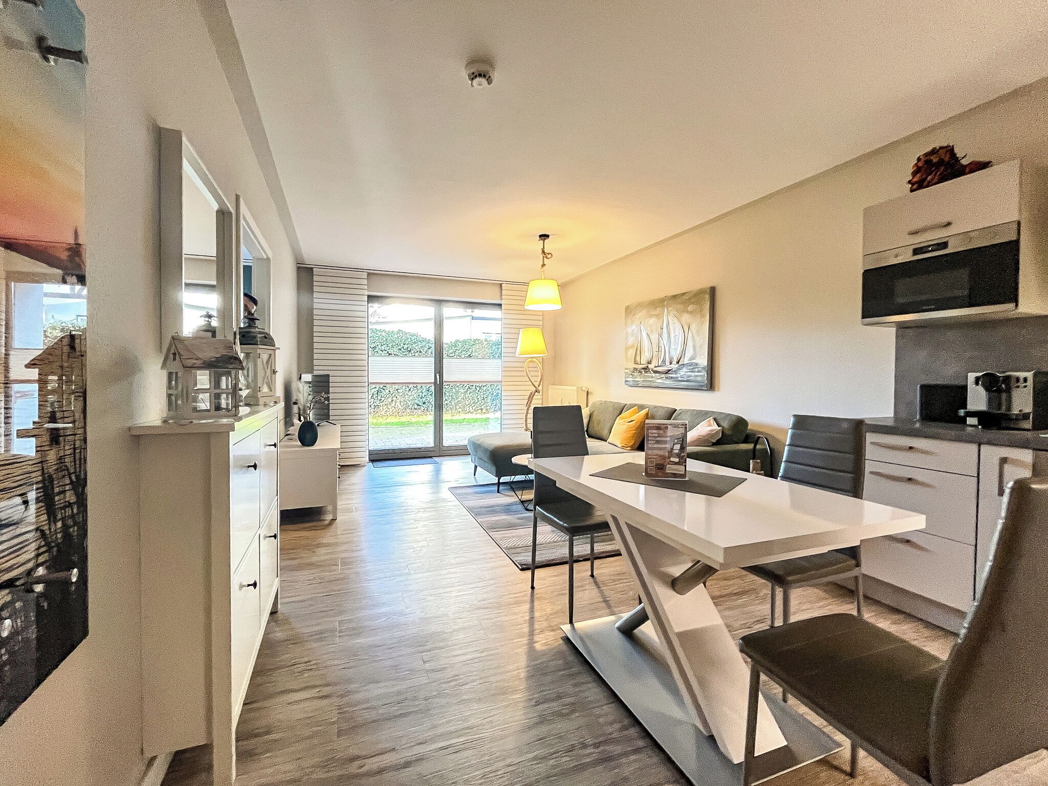 Eine moderne Küche mit Essbereich, einer Couch und Blick ins Freie.