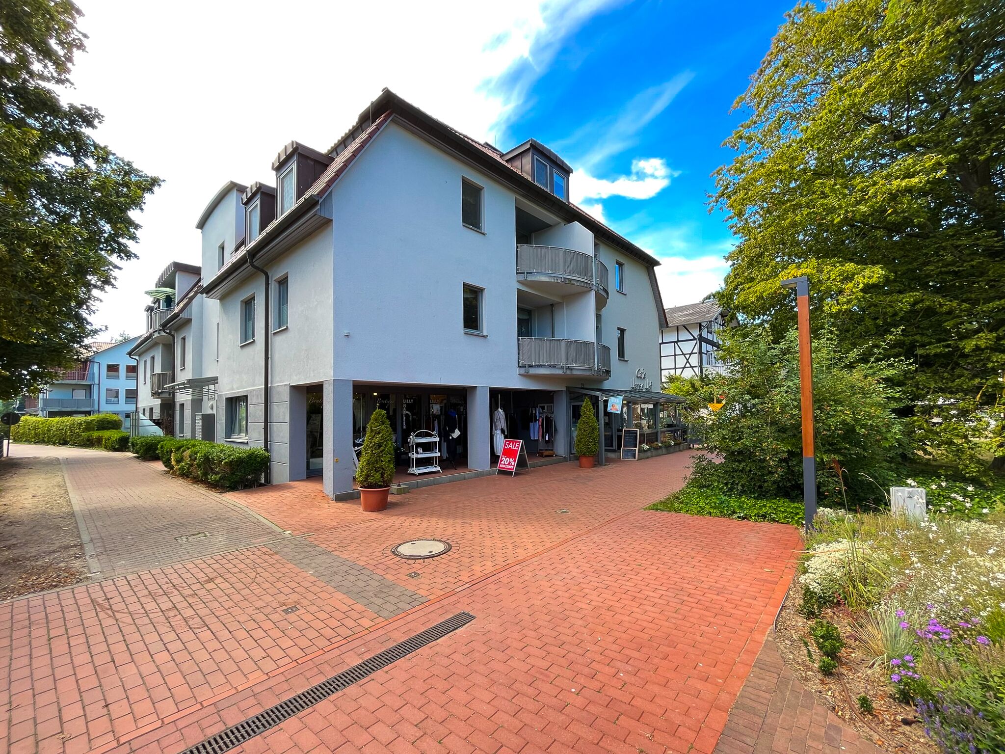 Un edificio moderno de dos pisos con techo plano, amplias ventanas y un balcón.