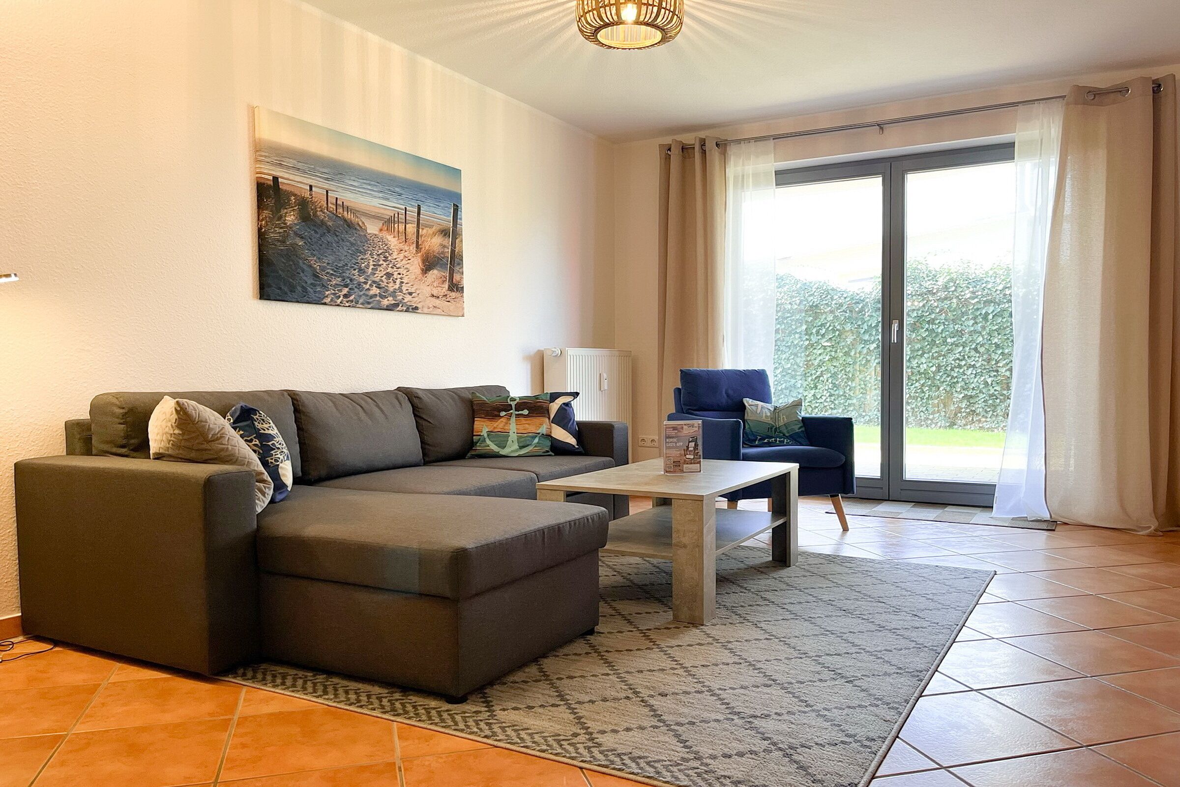 A living room with a sectional sofa, a coffee table, and a view through a glass door to an outdoor area.