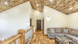 Un vaste espace de vie doté d’un plancher en bois, d’un grand canapé et d’une table basse.