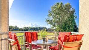 A terrace with a round table and four chairs, each with red-striped cushions. - Die Ferienwohnung 21 in der Anlage Godewind ist Eine 3-zimmerwohnung für bis zu (Ostseebad Boltenhagen)