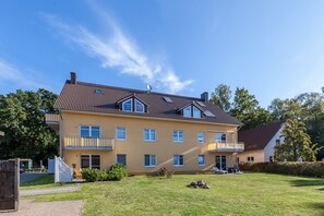 A two-story residential building with a tiled roof, multiple windows, and balconies. - Villa Bernstein Wohnung 06 (Ostseebad Boltenhagen)