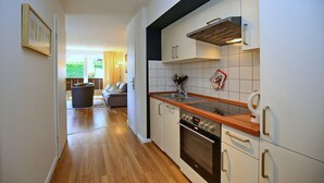 Une cuisine moderne avec des armoires blanches, un plan de travail en bois et un four encastré.