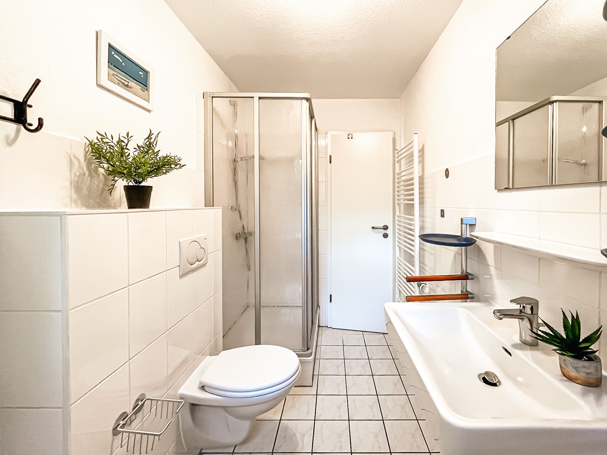 A modern bathroom with a toilet, sink, and shower.
