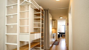 A hallway with a white closet with shelves and a wooden floor. - Papillon Wohnung 10-8 (Ostseebad Boltenhagen)