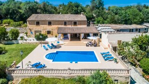 Une grande villa dotée d’une piscine, d’un espace extérieur aménagé et offrant une vue sur le paysage environnant.