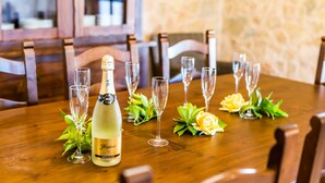 A wooden dining table with a bottle of champagne, empty wine glasses, and decorative flowers. - Country house in Mallorca Cas Cuni with pool (Felanitx)