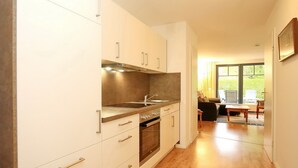 Eine moderne Küche mit weißen Schränken, Edelstahlgeräten und Holzboden.
