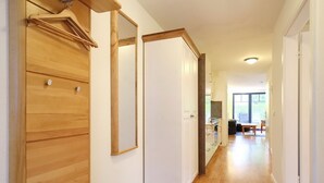 Ein Korridor mit Holzboden, einer weißen Tür und einem Spiegel an der Wand.