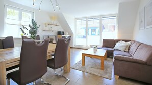 Ein modernes Wohnzimmer mit Essbereich, einer Couch und einem Couchtisch.
