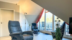 Un salon moderne doté d’un haut plafond, d’une grande fenêtre et offrant une vue sur l’extérieur.