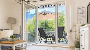 Un soggiorno moderno con una porta vetrata che si apre su un patio esterno.