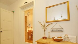 A room with a wooden dresser, a mirror, and a welcome sign. - Dünenblick Wohnung 05 (Ostseebad Boltenhagen)
